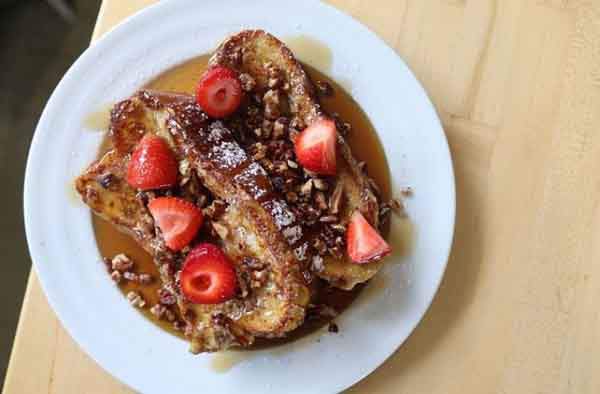 Homegrown signature dishes  Cinnamon Swirl French Toast, Various Benedicts (e.g., Avocado Benny), Breakfast Burrito, Quinoa Porridge, freshly pressed juices.